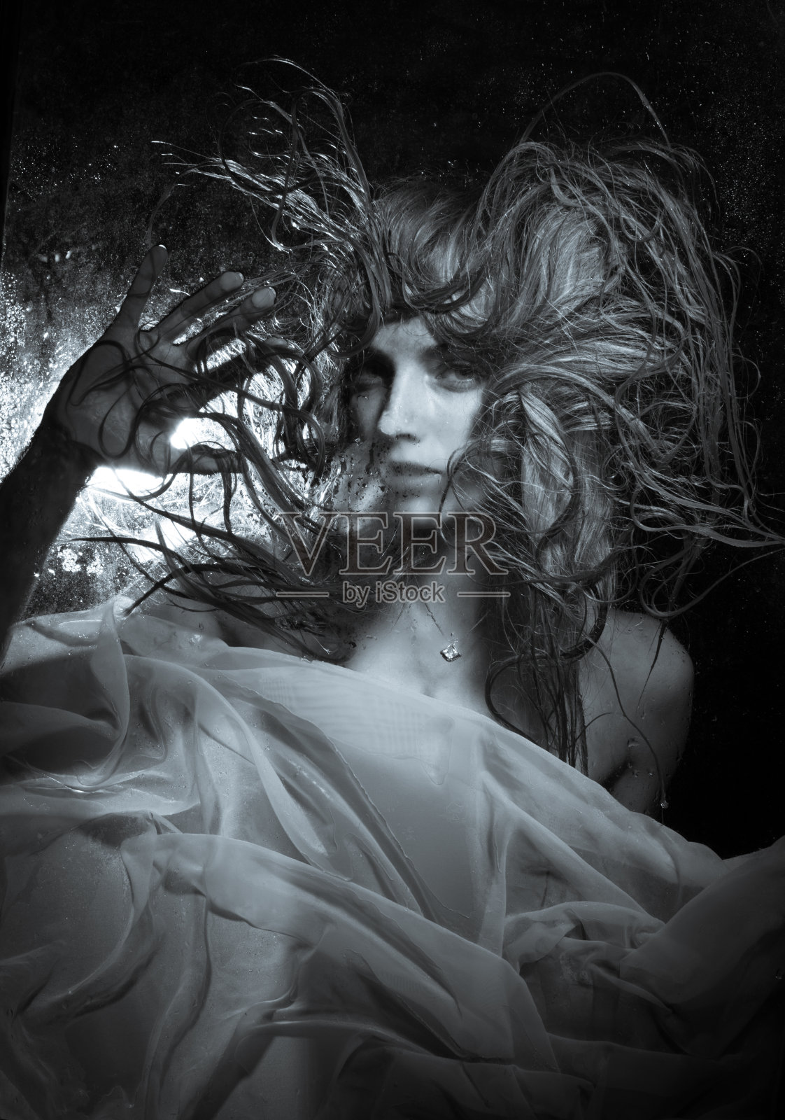 女孩在湿玻璃后面照片摄影图片