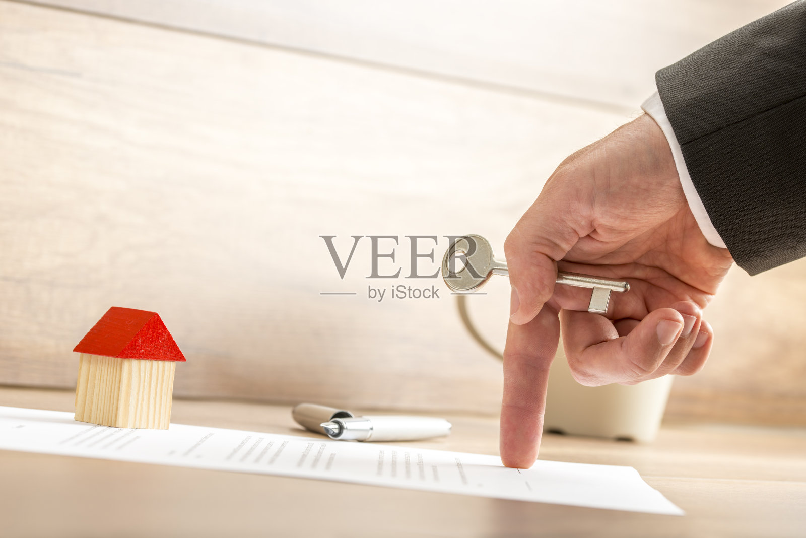 房地产经纪人在出示合同的同时持有房子钥匙照片摄影图片