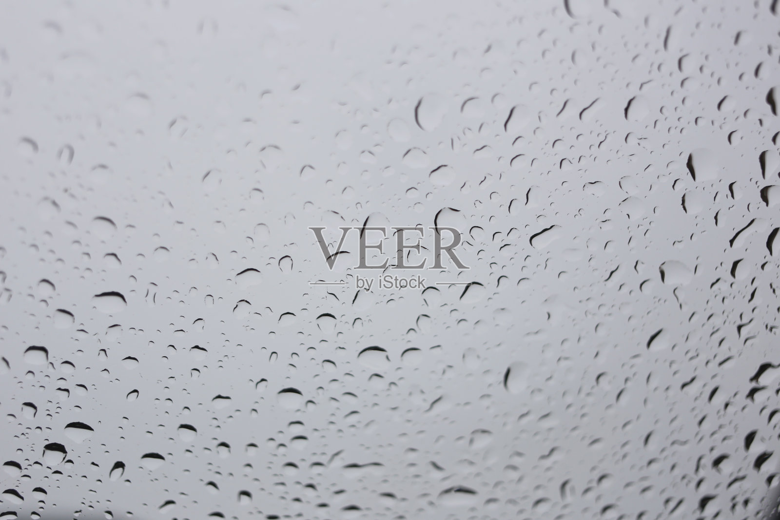 雨滴落在玻璃背景上。照片摄影图片