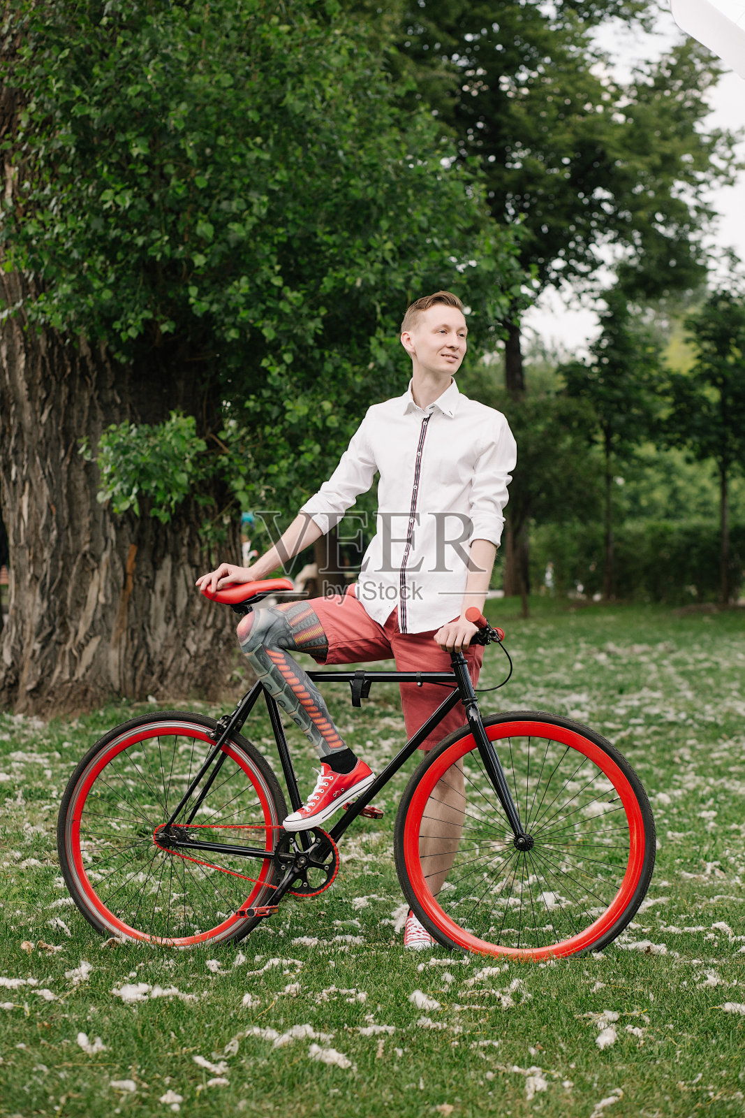 骑着自行车,腿上有纹身的潮人照片摄影图片