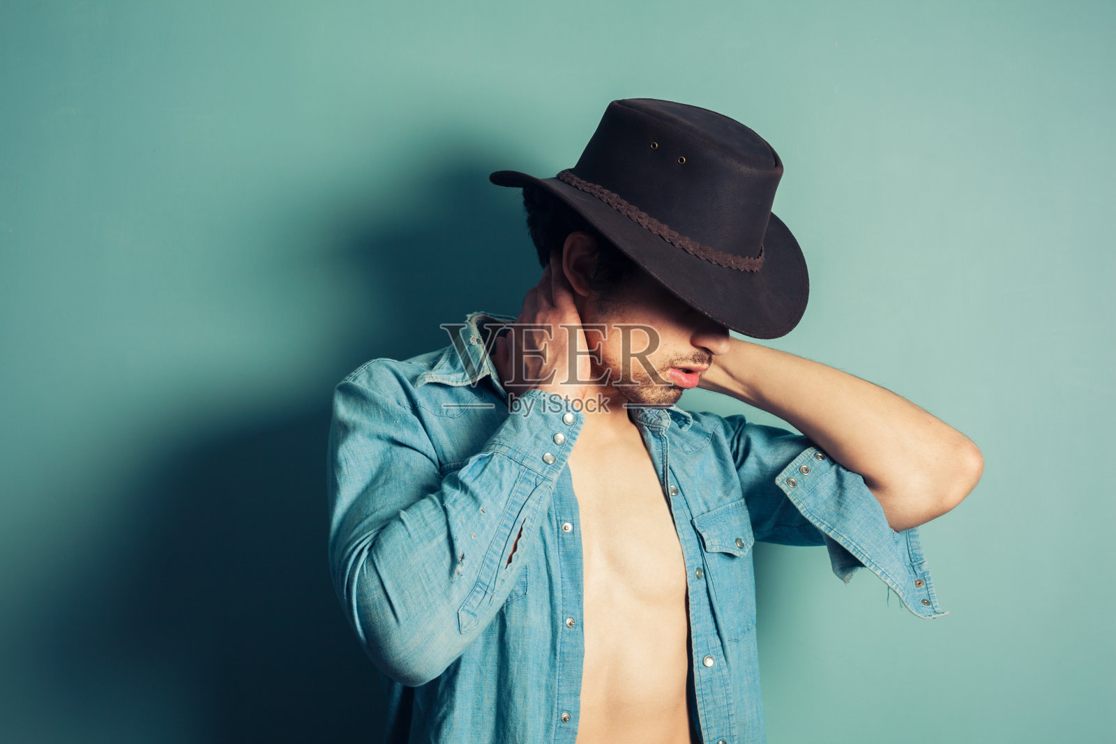 穿着敞开衬衫的性感年轻牛仔照片摄影图片