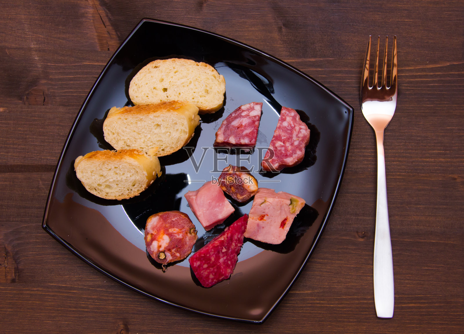 从上面的木头上放上几片意大利腊肠和面包片照片摄影图片