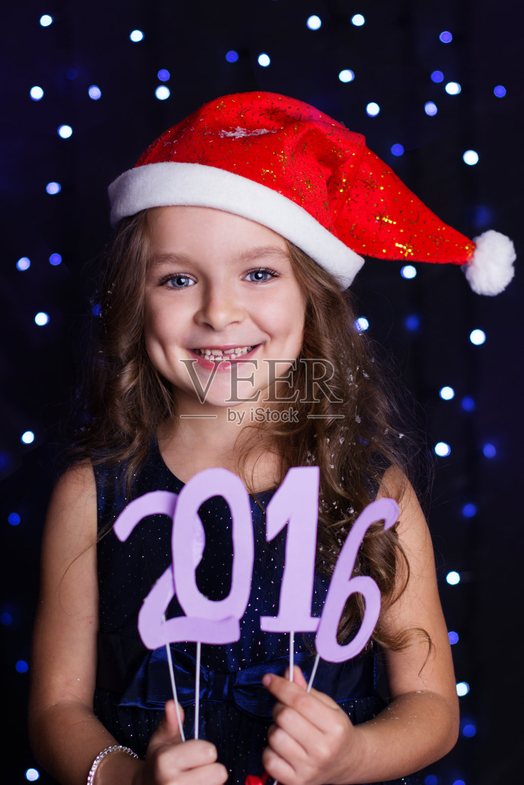 圣诞女孩正拿着2016年的纸俑,过圣诞节照片摄影图片
