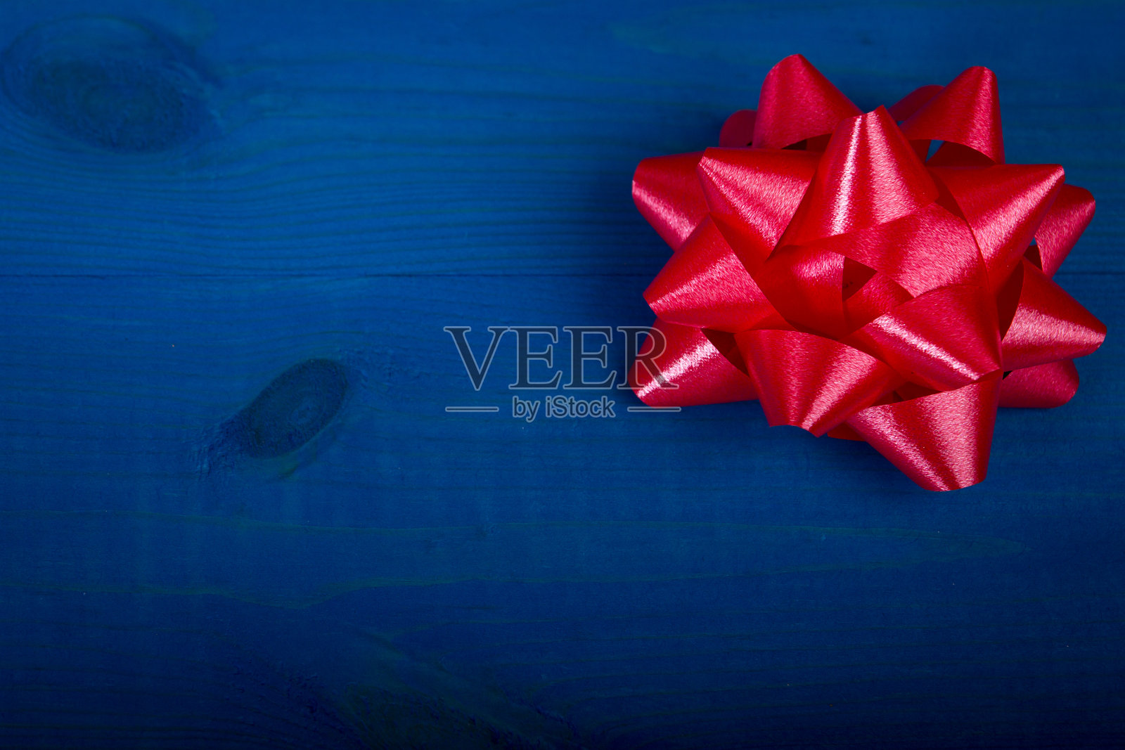 蓝色木板上的红色蝴蝶结照片摄影图片
