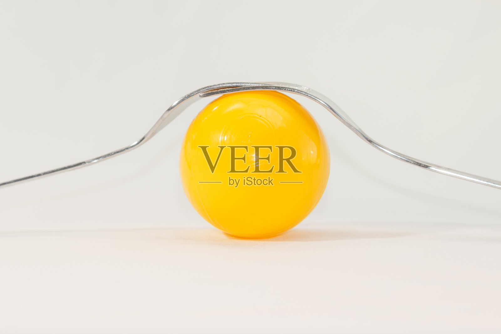 两个叉子和彩色的球在白色的背景照片摄影图片