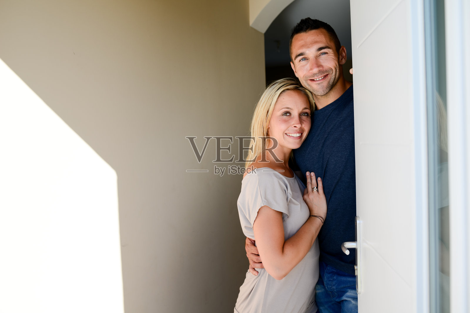 新婚夫妇在新房子的前门欢迎朋友照片摄影图片