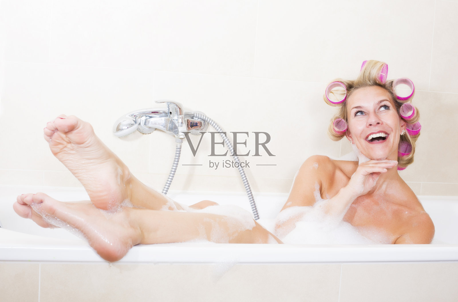 浴缸里带卷发器的女人照片摄影图片