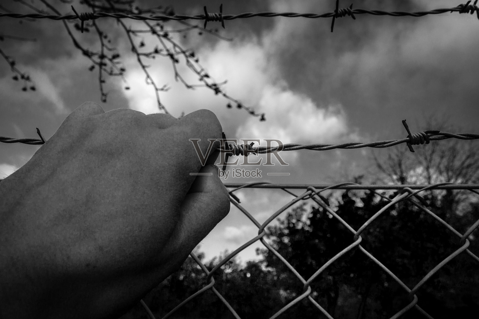 带刺铁丝网后的难民照片摄影图片