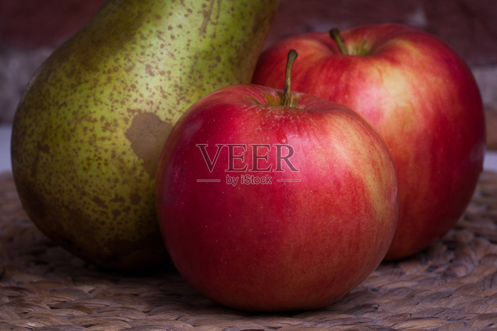 背景墙上有绿梨和红苹果。照片摄影图片