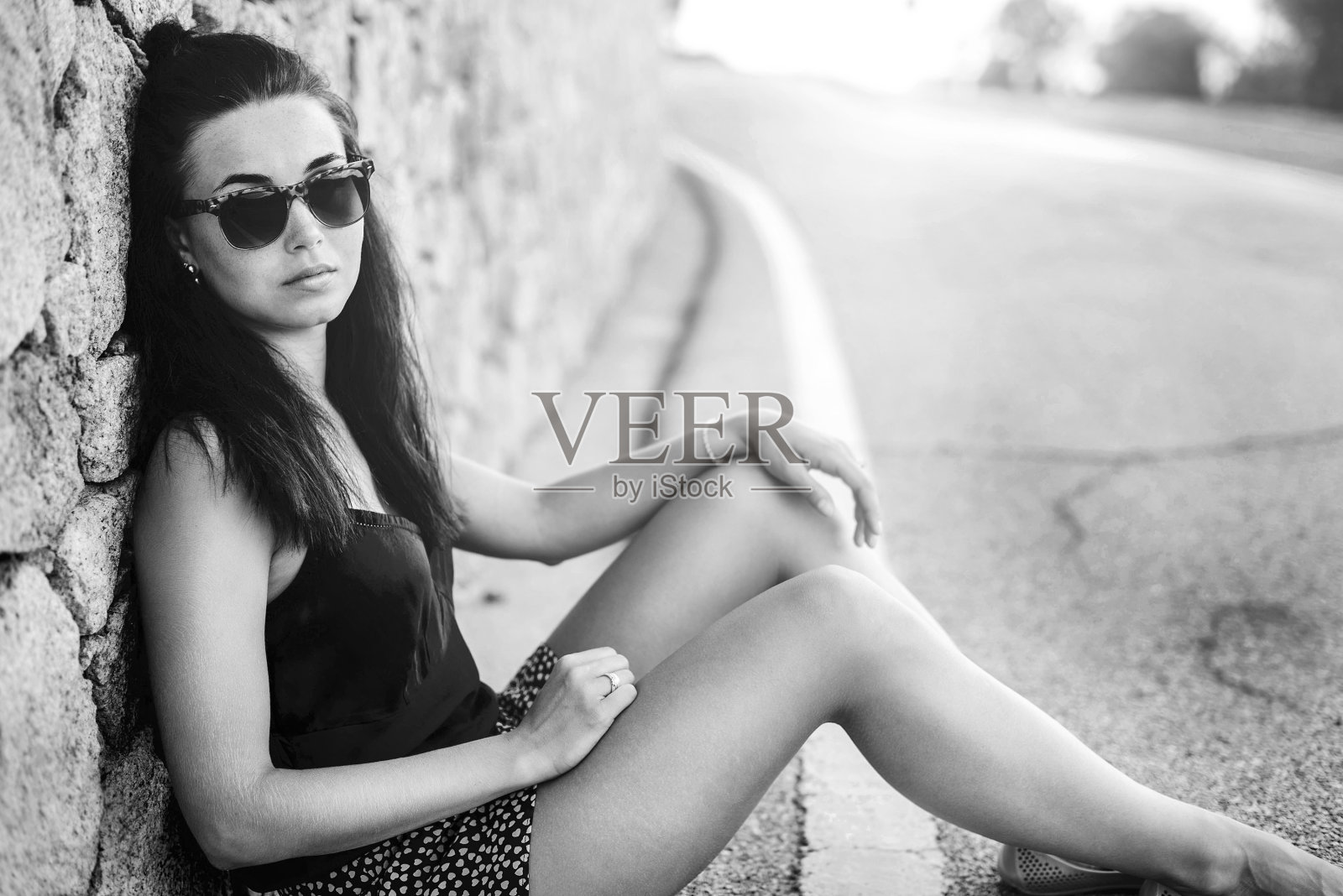 漂亮的黑发女游客坐在路上照片摄影图片