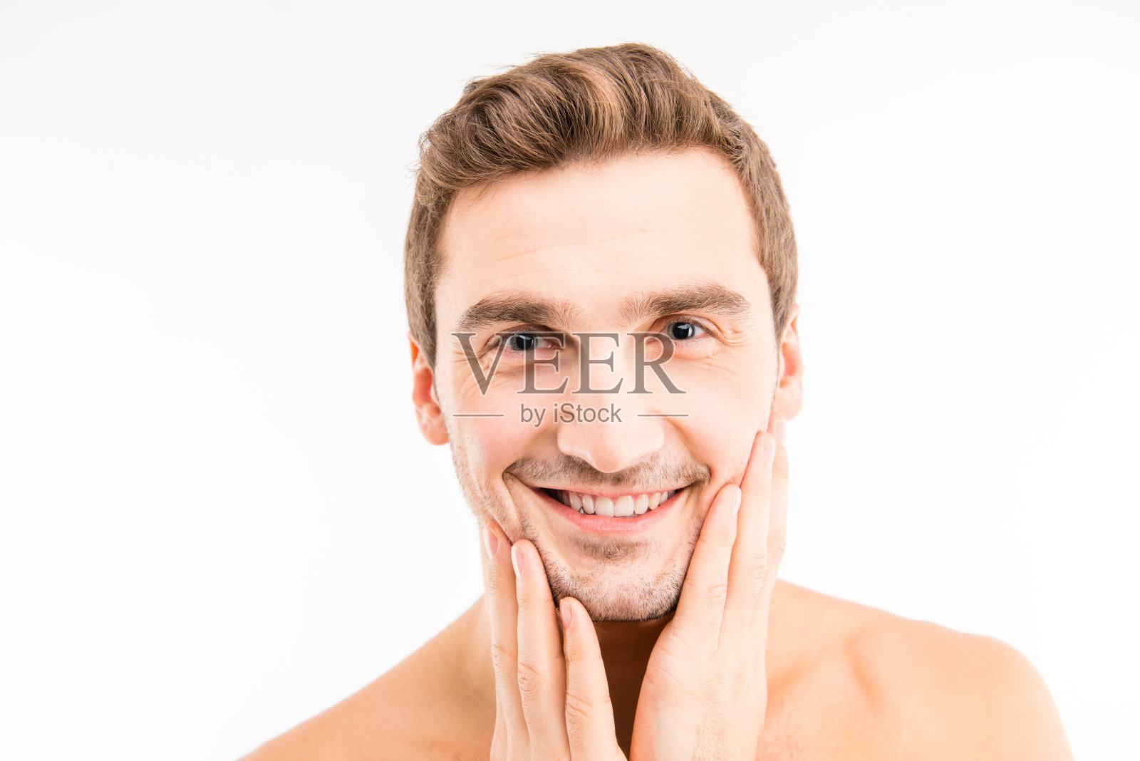 英俊的男子在刮胡子后摸脸照片摄影图片