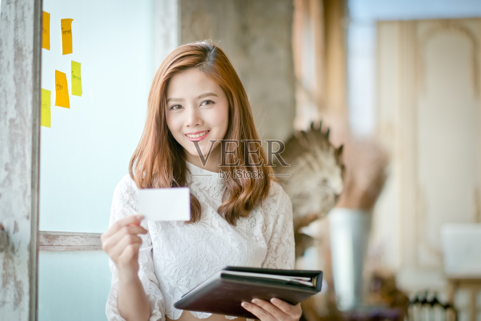 微笑着的美丽女商人,展示着空白的名片照片摄影图片