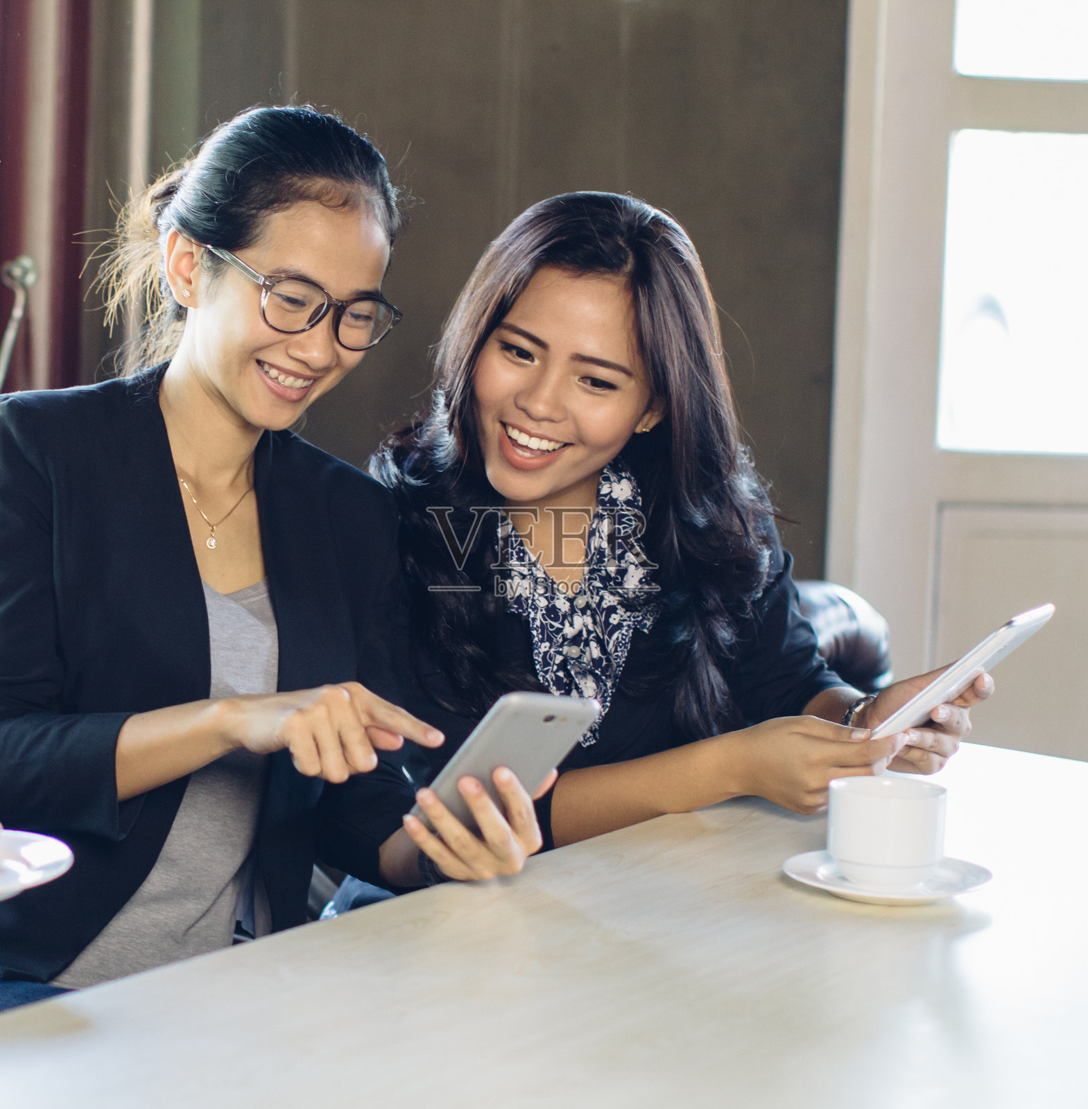 两个女人在谈论智能手机照片摄影图片