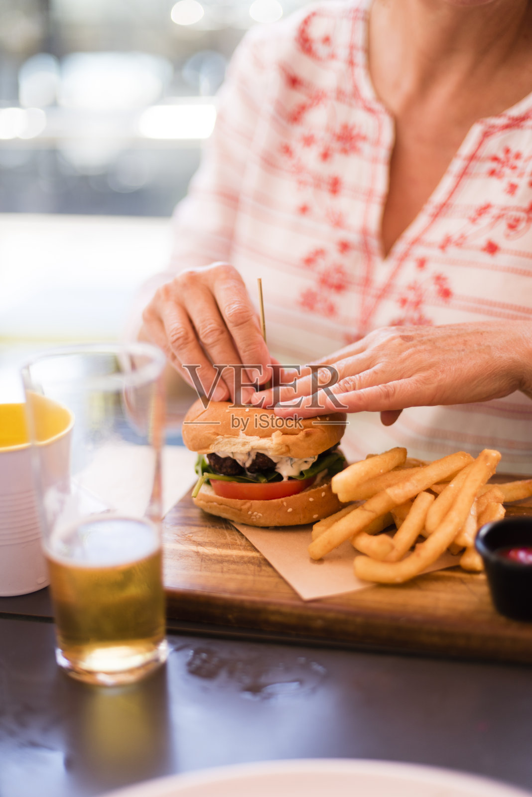 午餐吃汉堡的成熟女人照片摄影图片