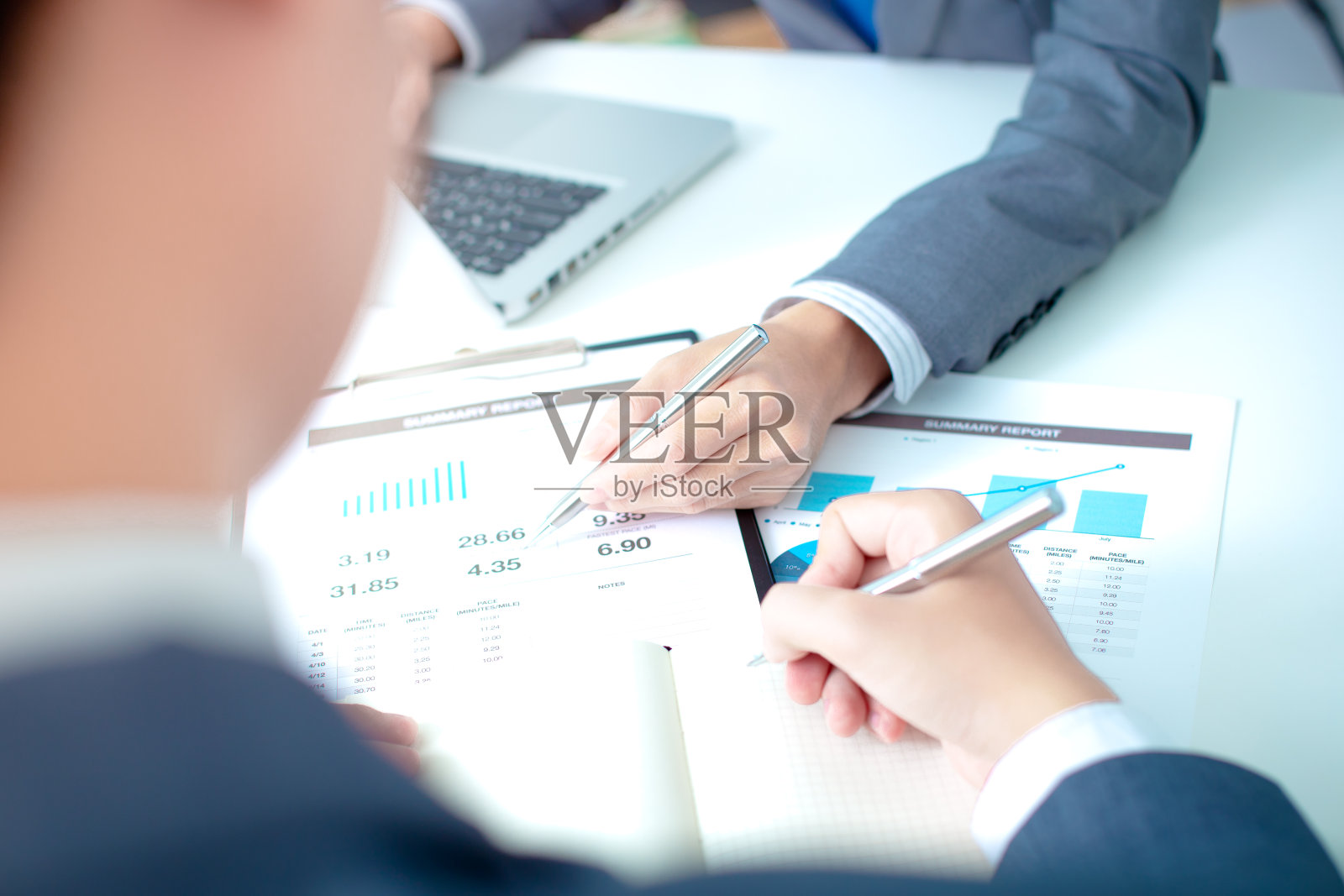 两个商人一边看报告一边进行讨论照片摄影图片