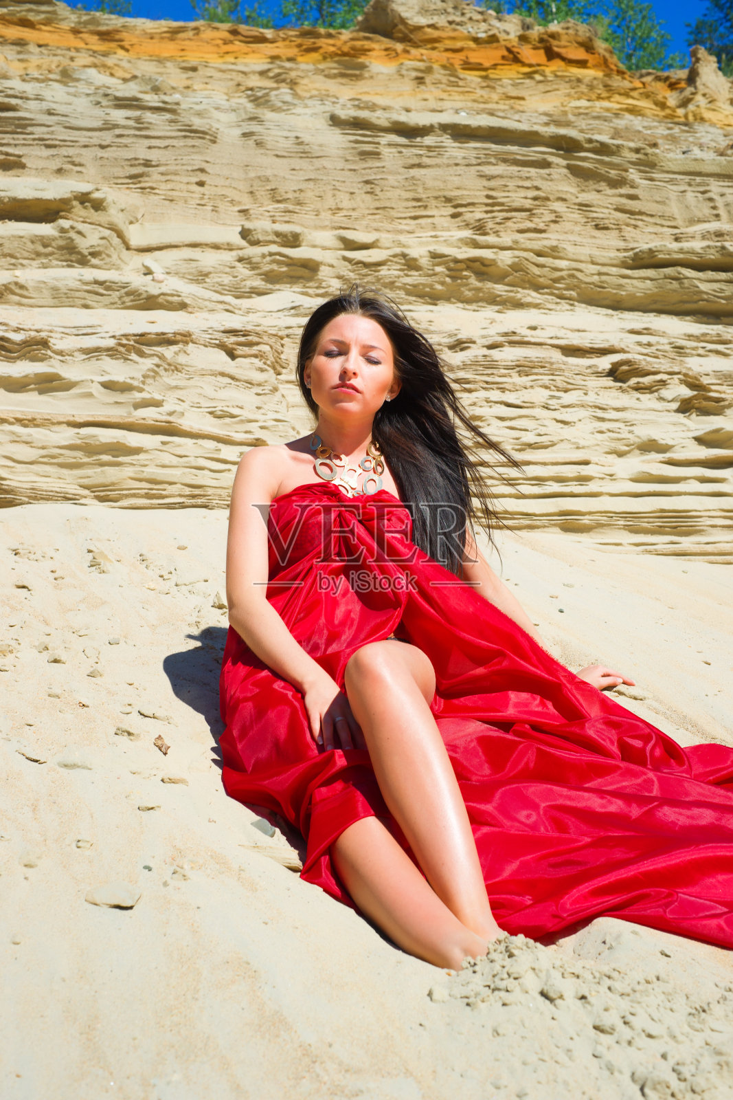 海滩上穿着红色衣服的女士照片摄影图片