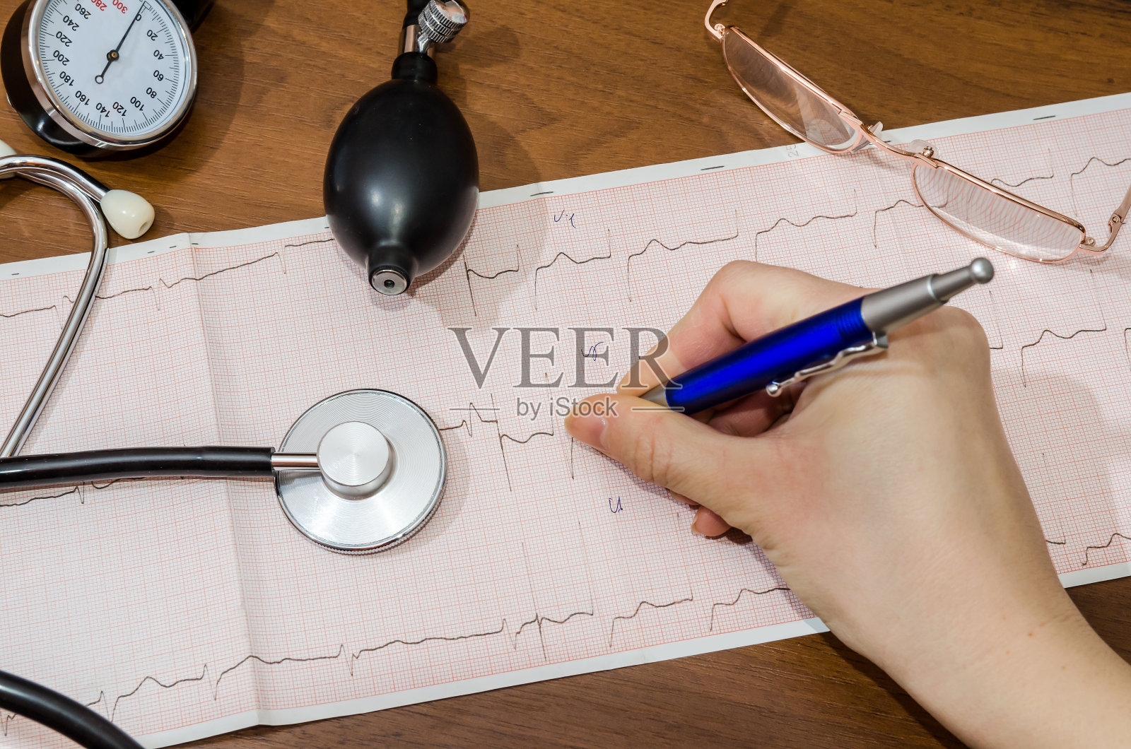 女医生手拿心电图。脉冲照片摄影图片