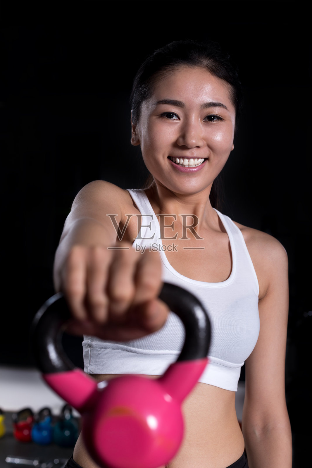 年轻漂亮的女孩在现代健身房锻炼照片摄影图片