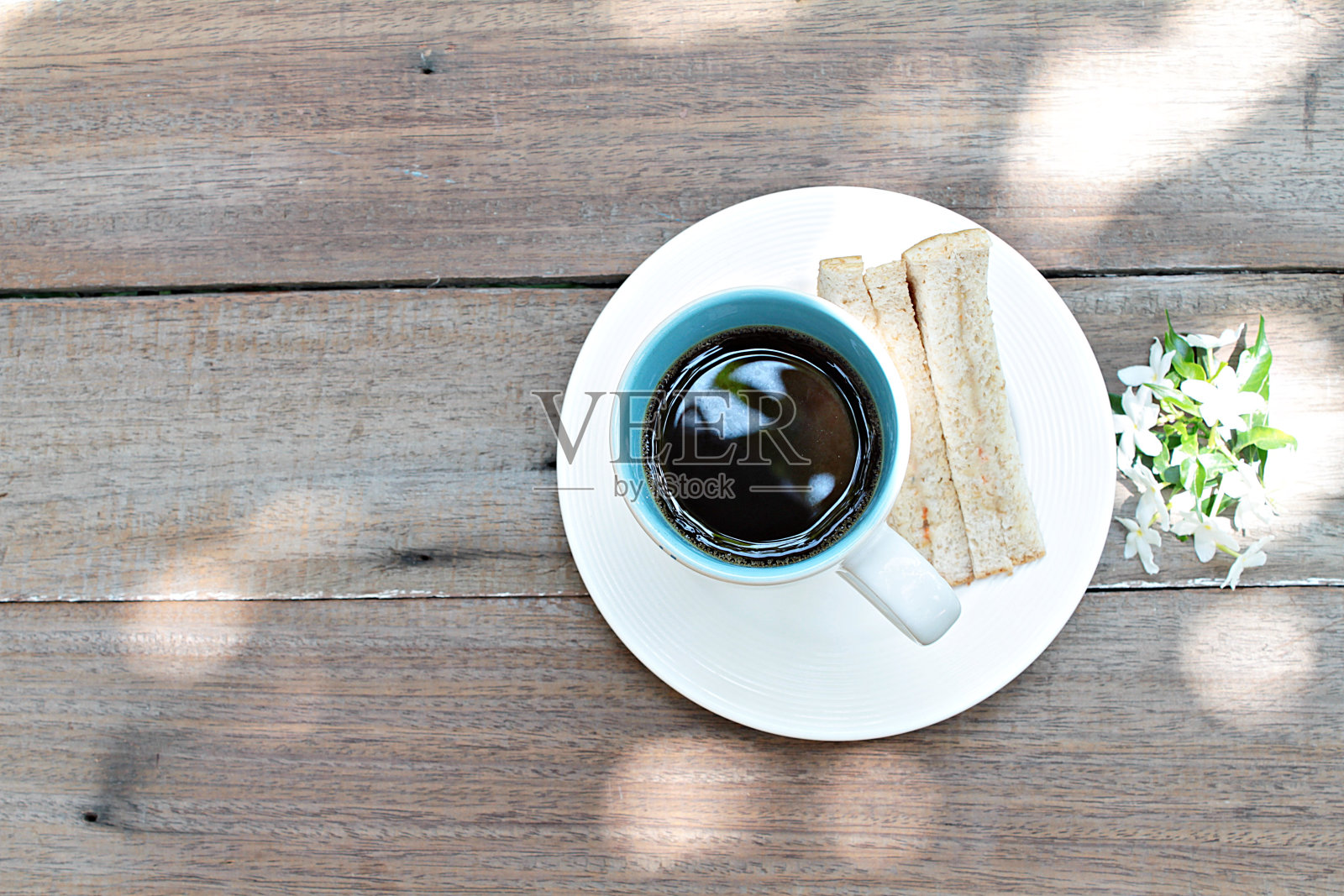 一杯咖啡,三明治和白花在木头背景照片摄影图片