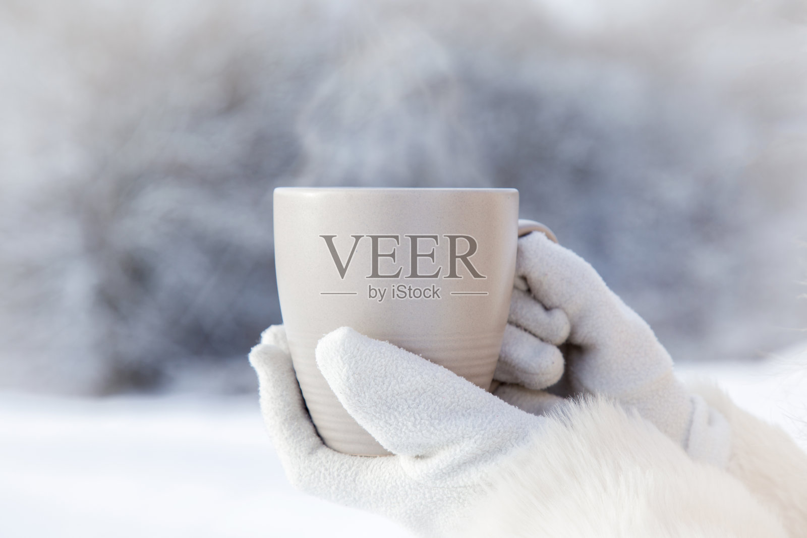 冬日里端着一杯咖啡的女人。照片摄影图片