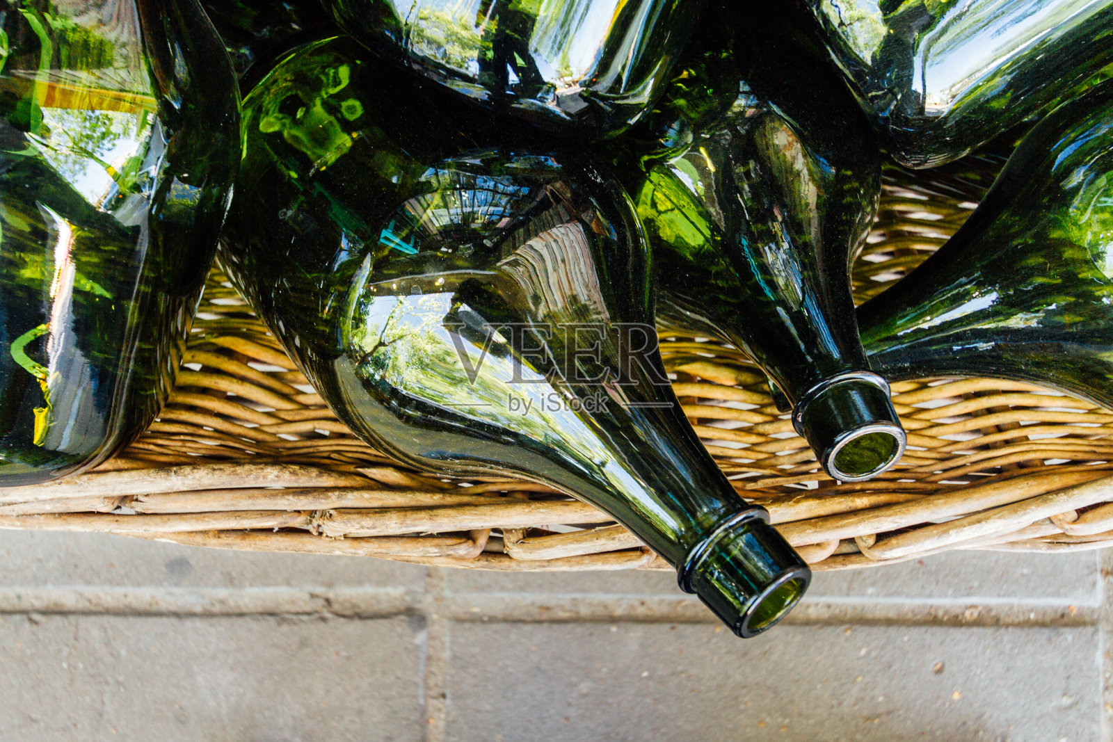几只绿色空瓶子堆放在柳条篮子里照片摄影图片