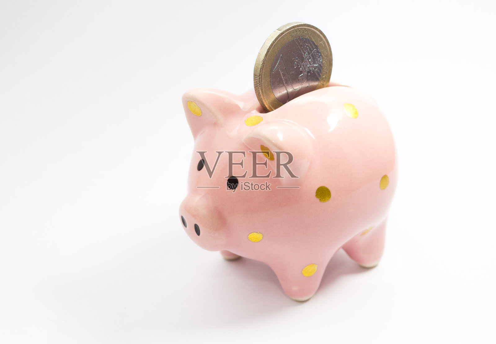 1欧元硬币掉进储蓄罐照片摄影图片