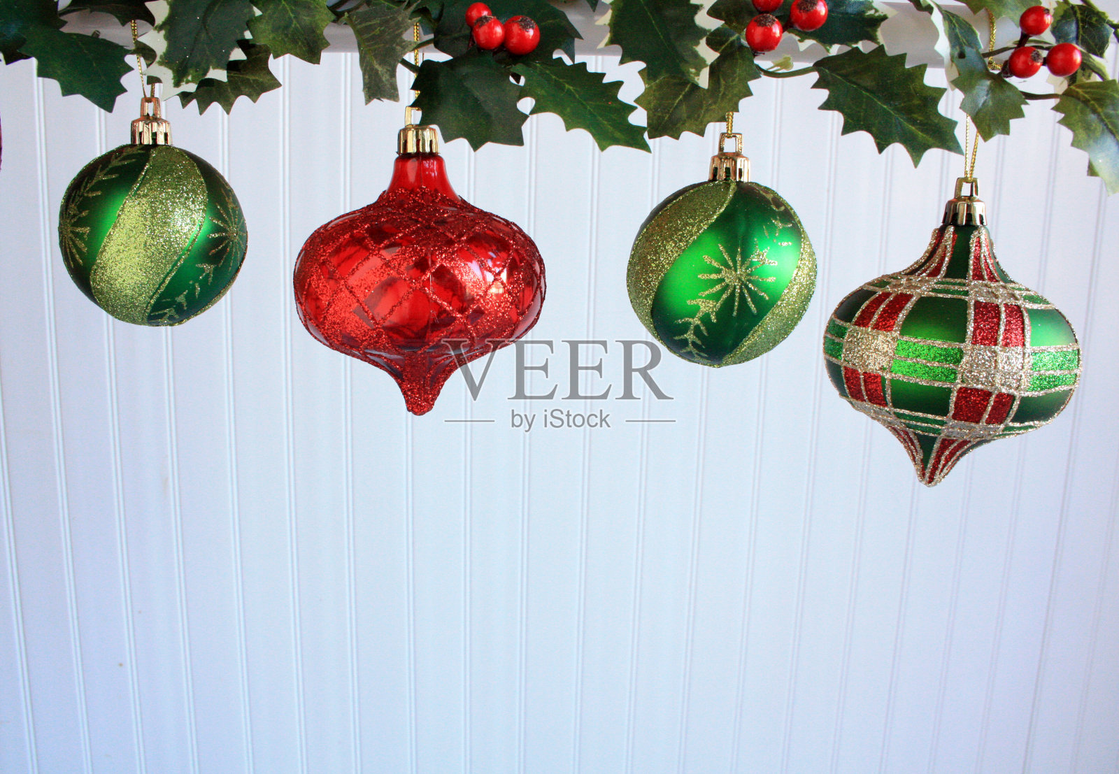 四个挂着冬青树叶的圣诞小玩意照片摄影图片