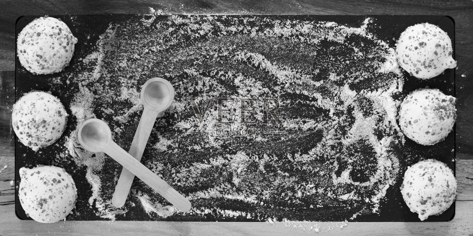 木板上放着白色的饼干。照片摄影图片