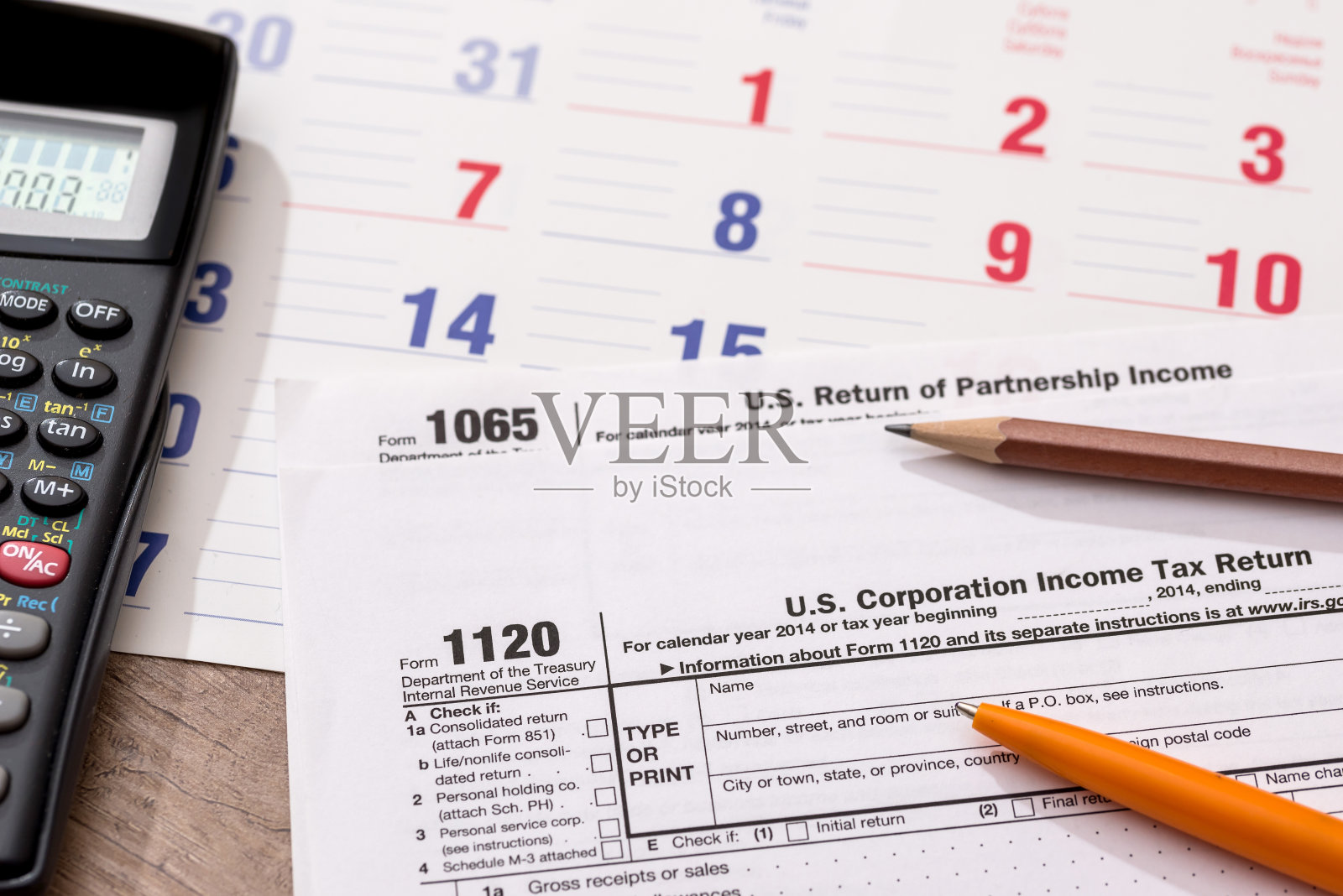 表格1120企业所得税申报表连同日历,计算器和笔照片摄影图片