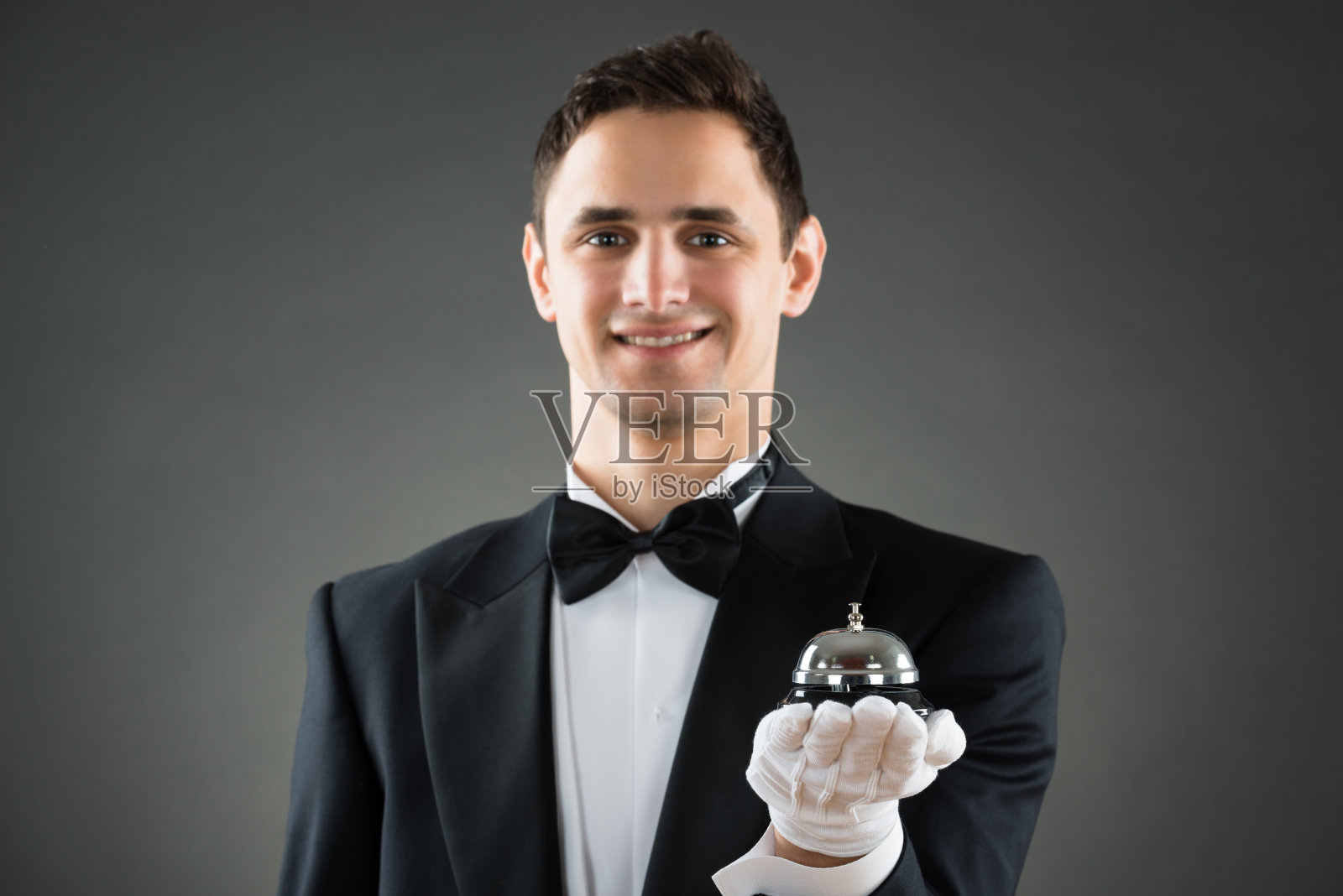 微笑的服务员保持服务铃照片摄影图片