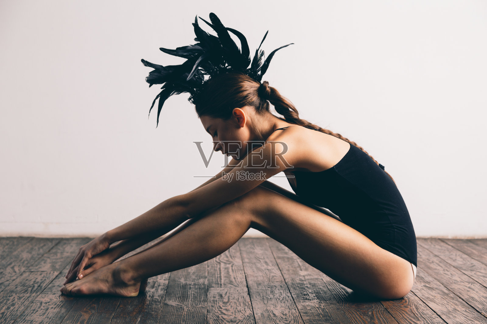 年轻性感的混血白人女性时尚肖像与羽毛照片摄影图片