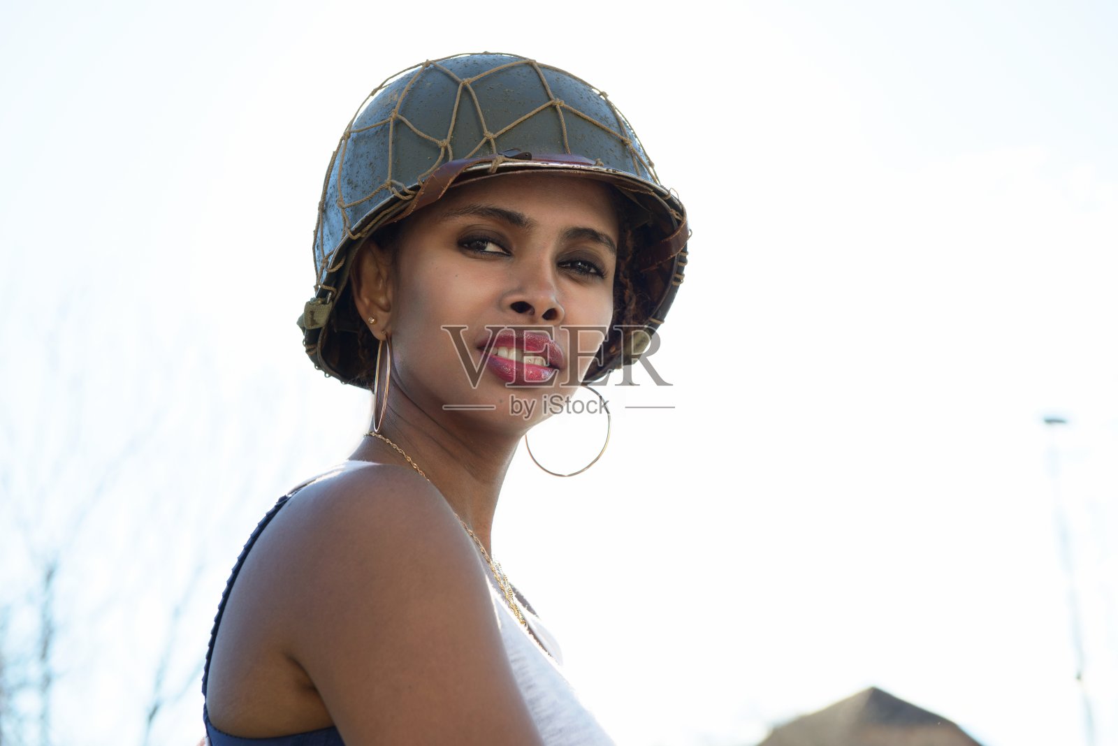 漂亮的年轻女人戴着二战军用头盔照片摄影图片