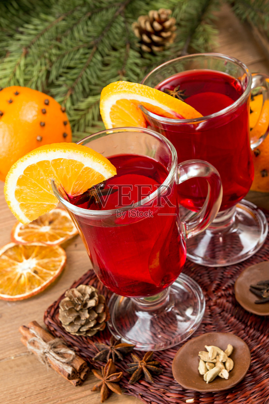 木桌上放着两杯热红酒。照片摄影图片