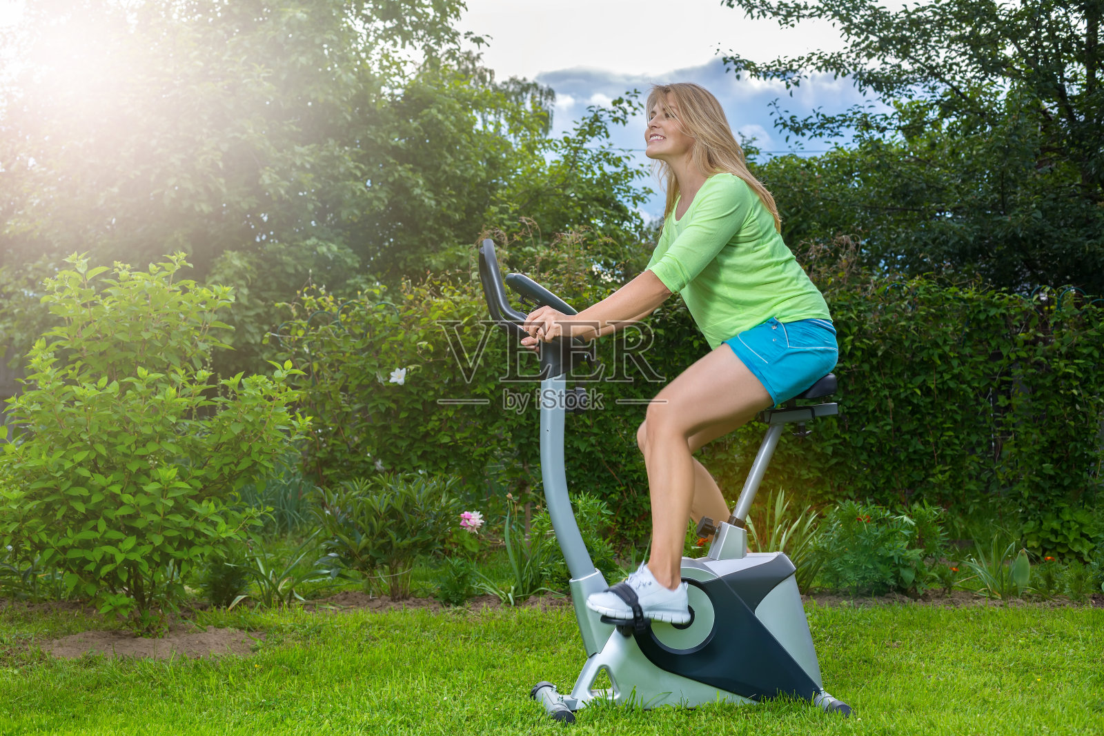 骑着健身自行车的金发美女照片摄影图片