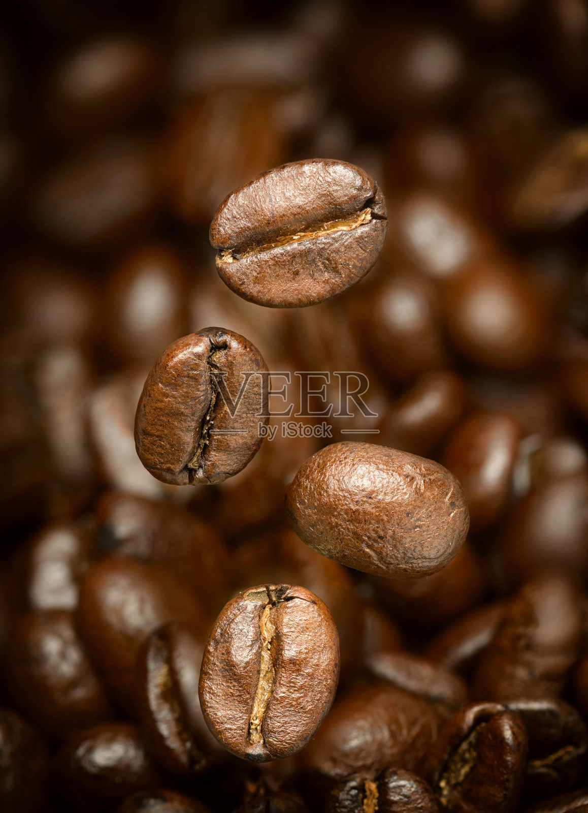 飞咖啡豆的微距照片。聚焦所有豆子。照片摄影图片