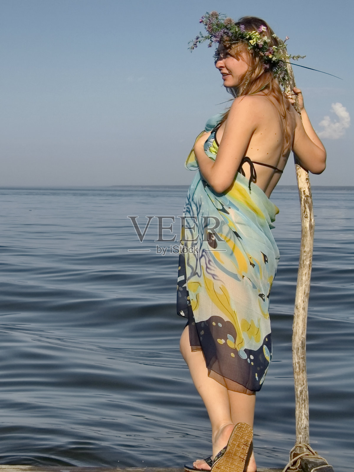 怀孕的少女在夏天的海边戴着花环照片摄影图片