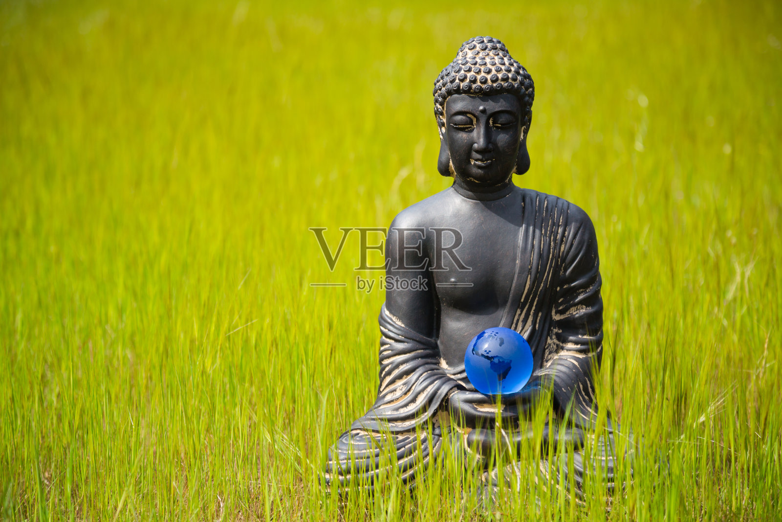 佛像小雕像与地球水晶球在自然界照片摄影图片