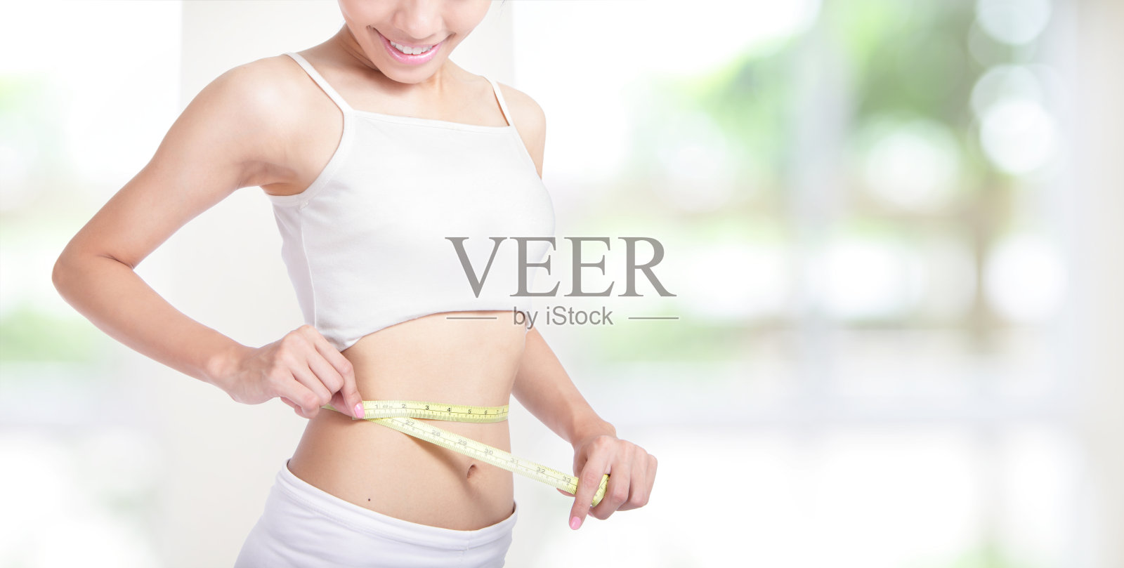 女人的微笑测量腰围的形状照片摄影图片