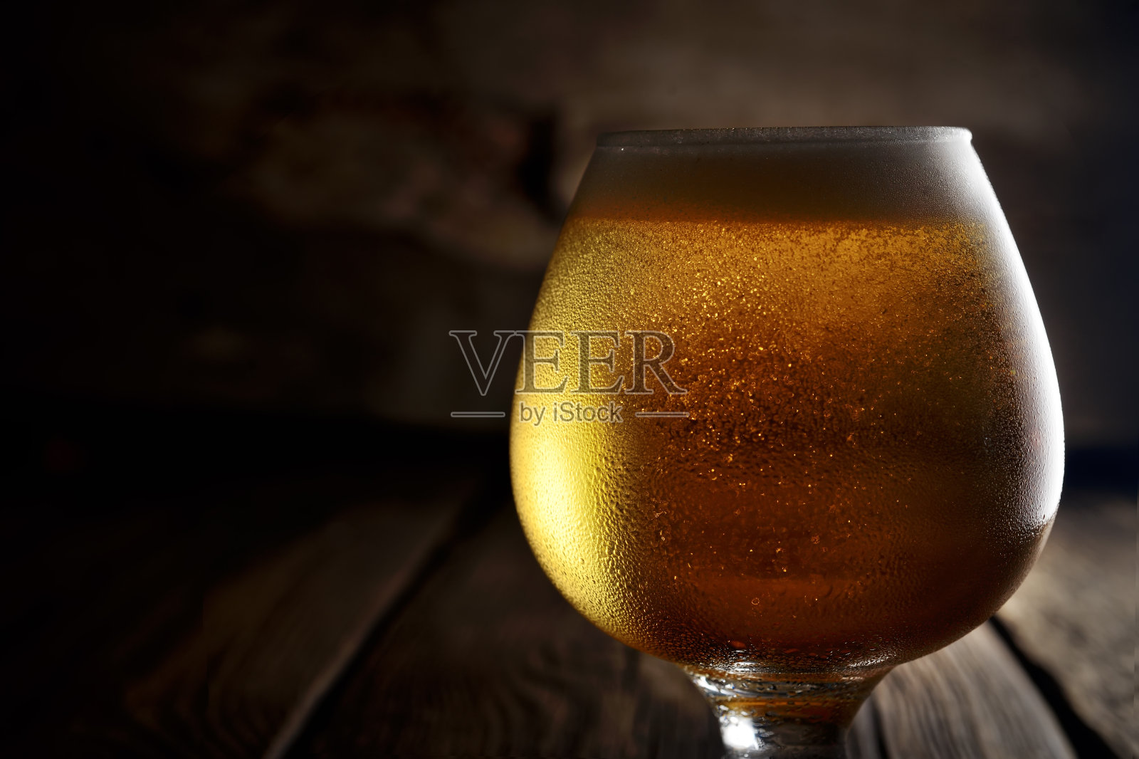 木制背景的玻璃杯里的啤酒照片摄影图片