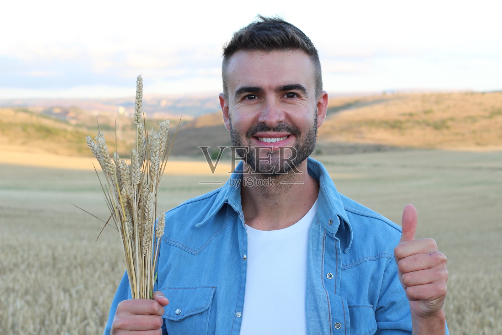 英俊的农民在竖起大拇指照片摄影图片