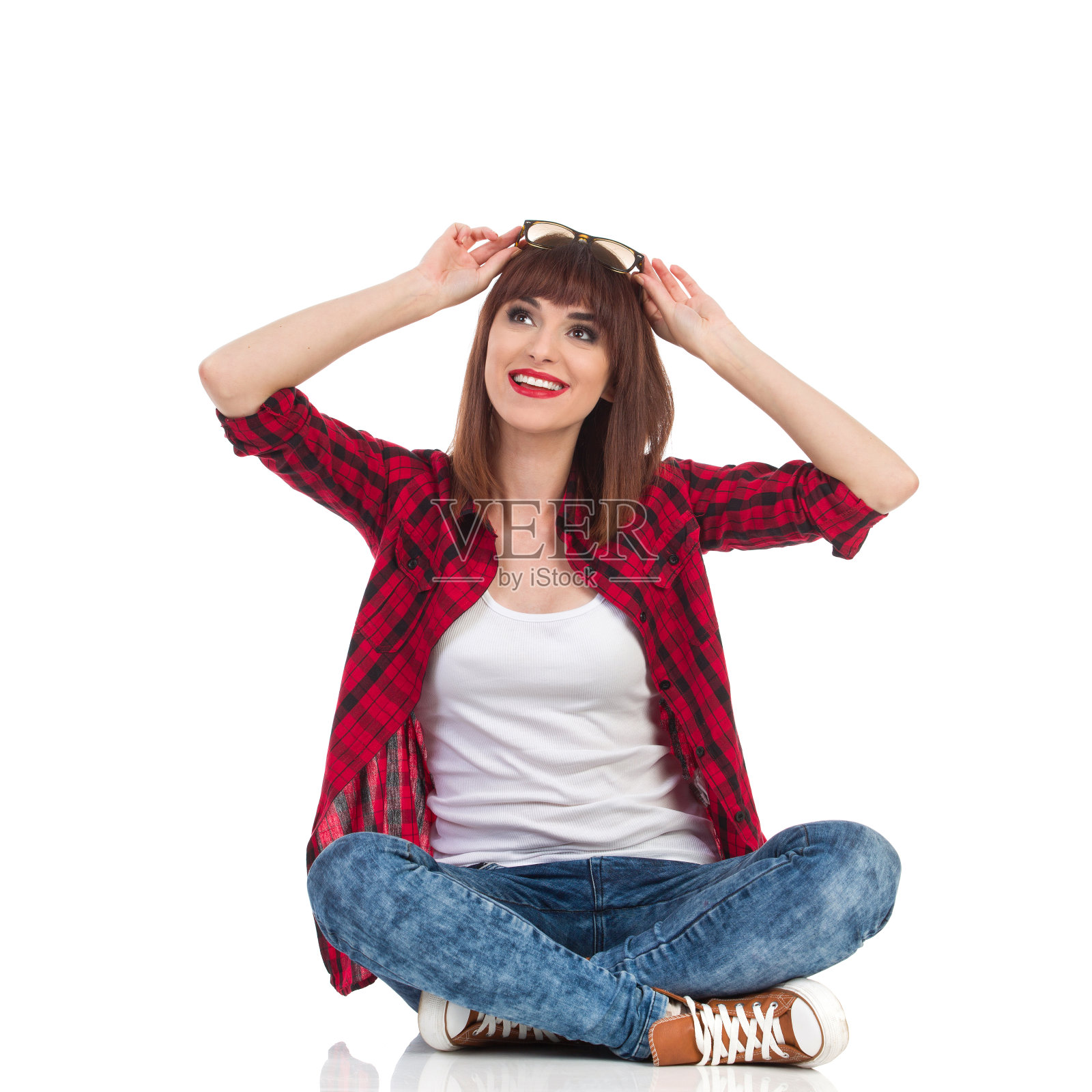 好奇的年轻女子双腿交叉坐着照片摄影图片