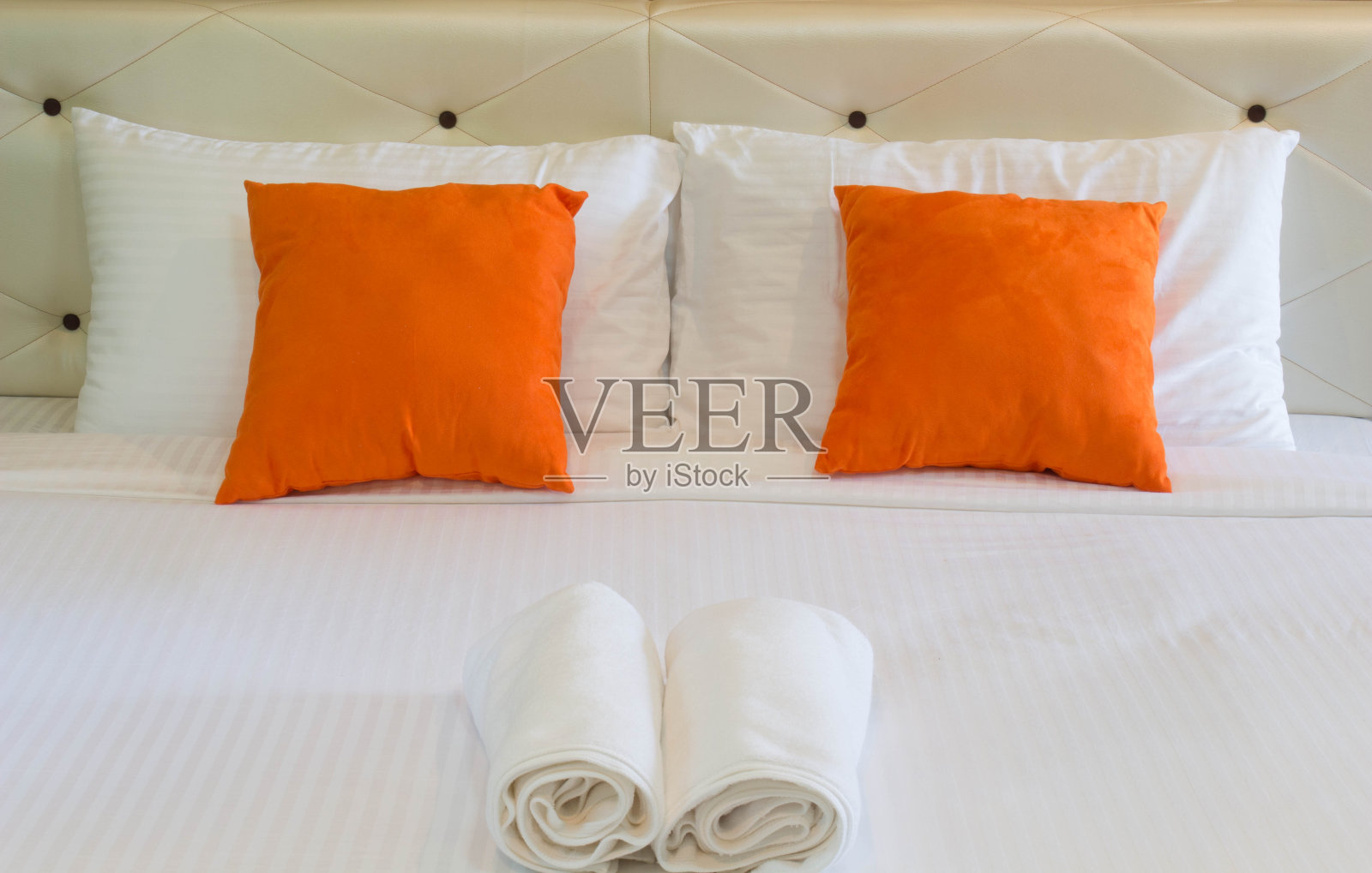 酒店床上的橙色枕头照片摄影图片
