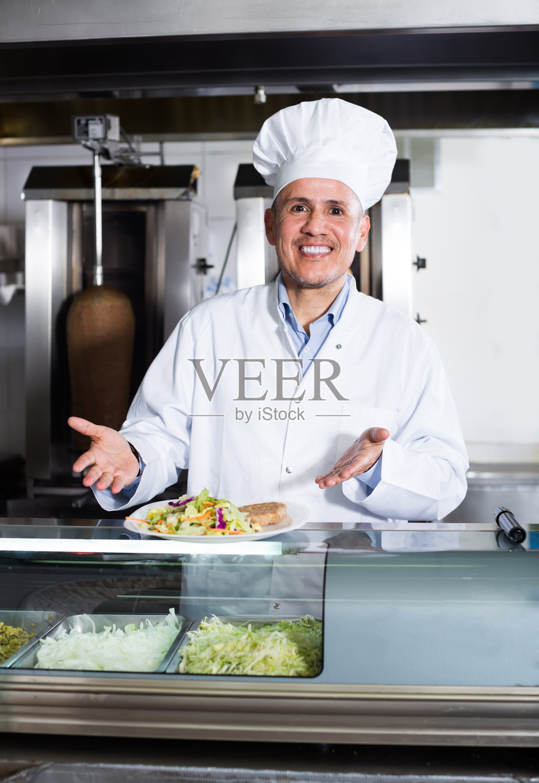 成熟的男性厨师拿着一盘新鲜的烤肉照片摄影图片