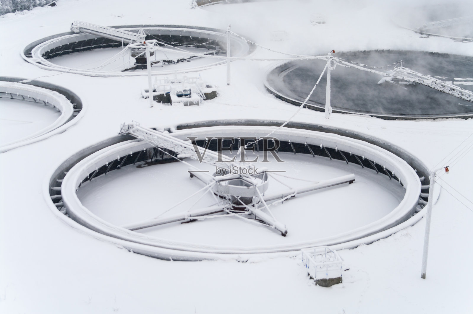 巨大的圆形定居者在水处理厂的雪下照片摄影图片