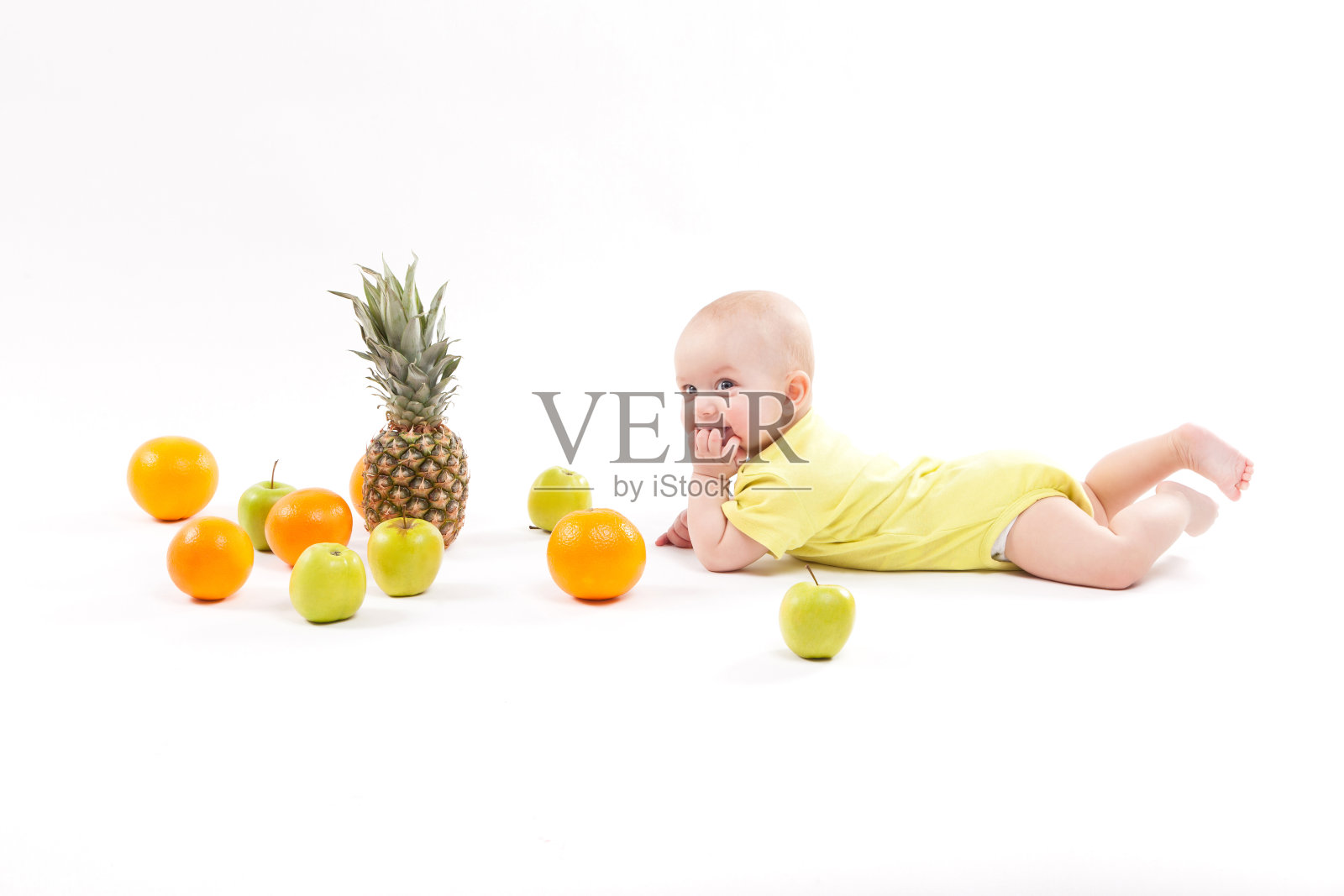 婴儿被白色背景的水果包围着照片摄影图片