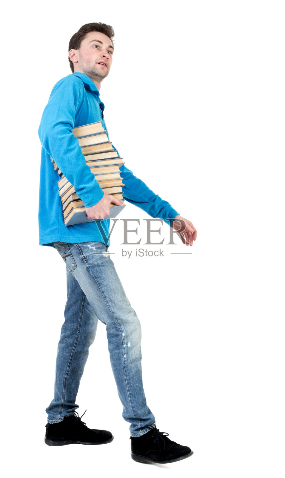 侧视图的人携带一叠书。照片摄影图片