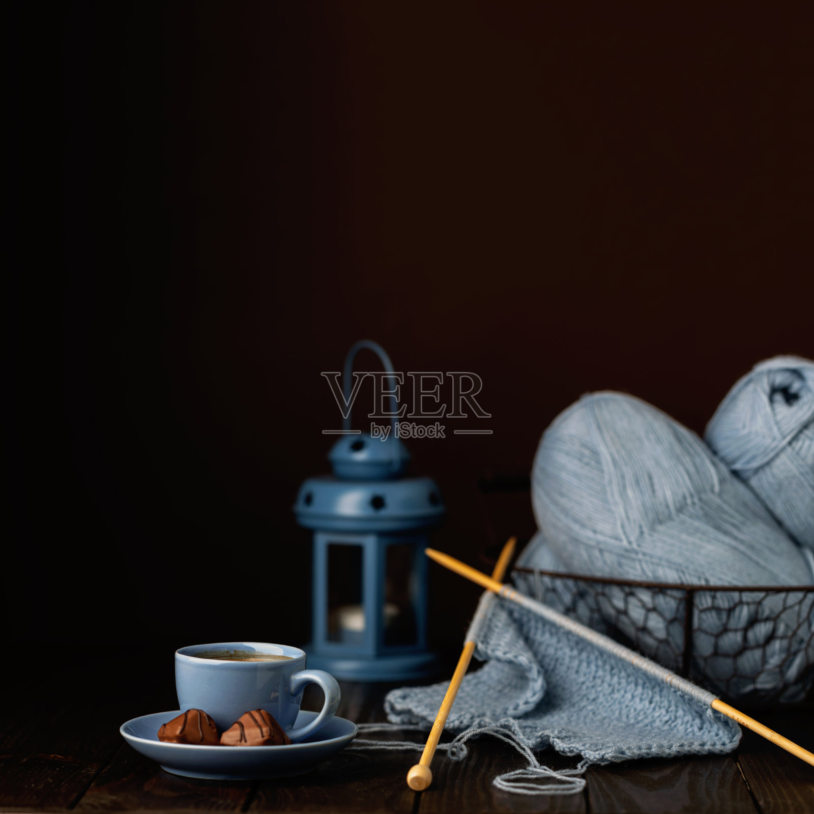 用浅蓝色纱线编织。一杯咖啡和巧克力。照片摄影图片