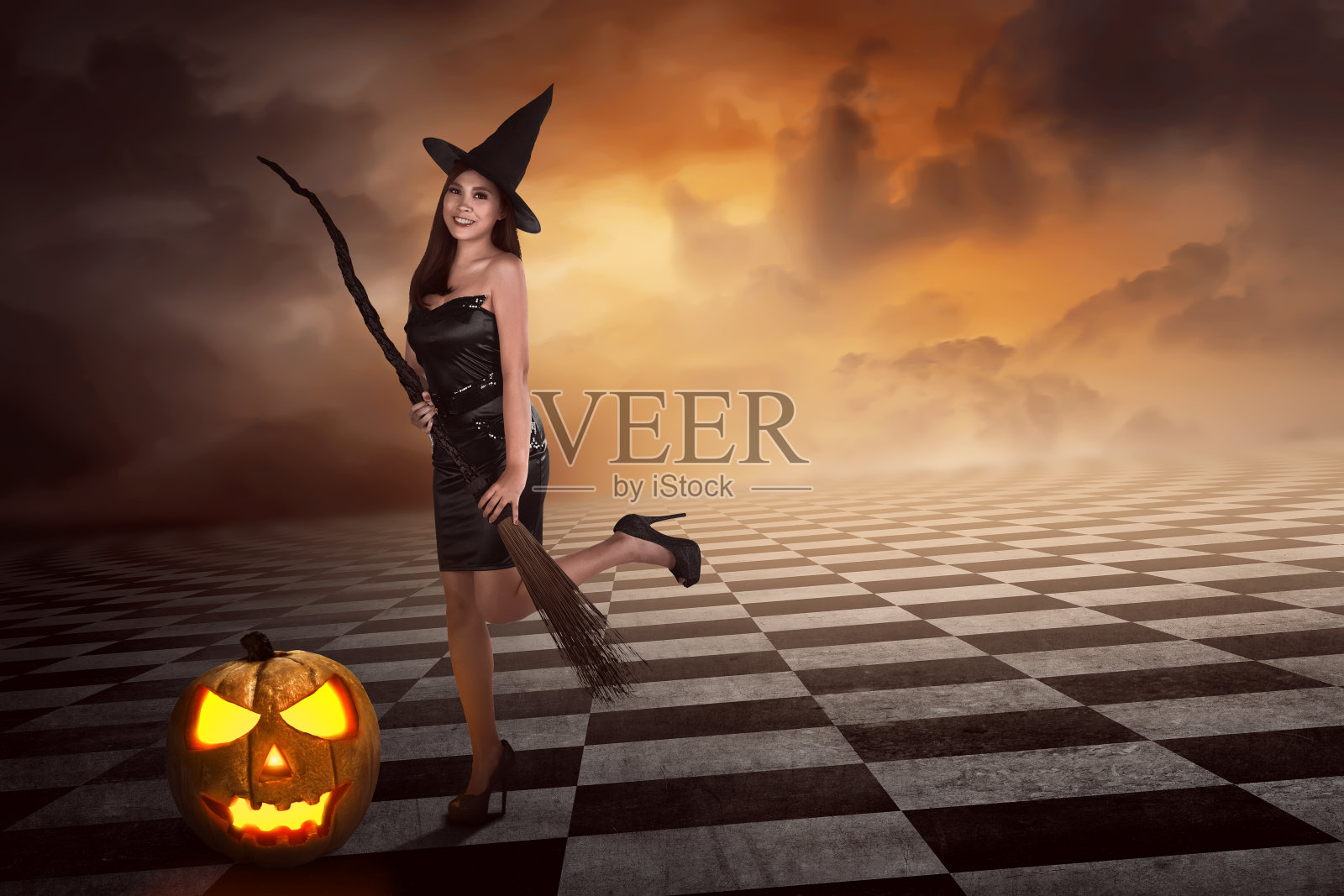 漂亮性感的年轻亚洲女巫拿着扫帚照片摄影图片