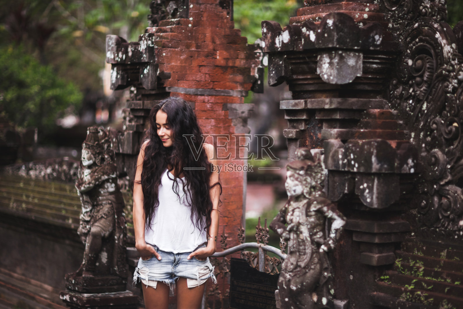 被巴厘建筑包围的黑发女子照片摄影图片