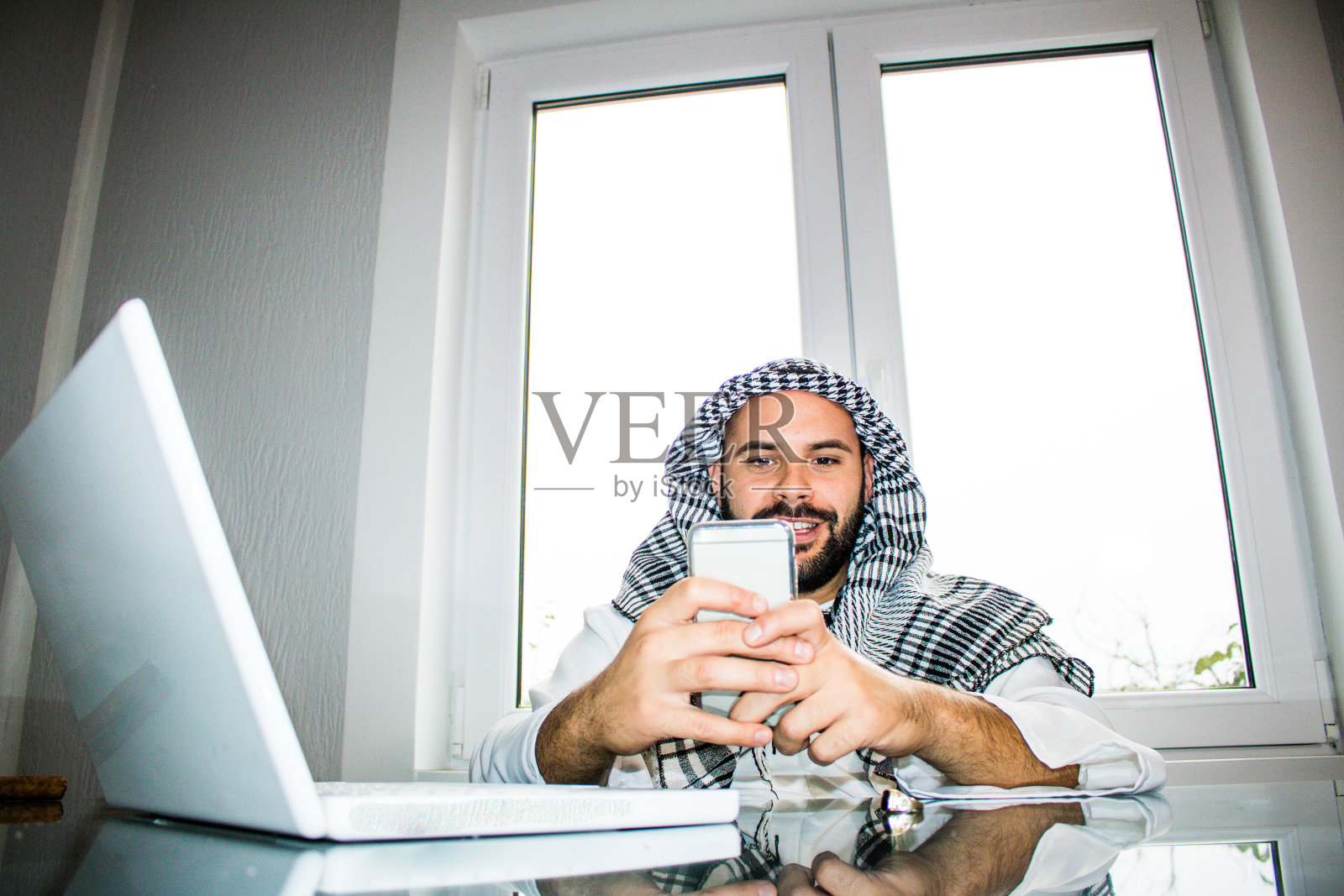 穿着传统服装的商人坐在办公室里照片摄影图片